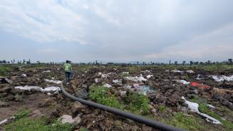 Zerwühlter Boden, Müll und dazwischen eine Wasserleitung, die eigentlich unter der Erde verlaufen sollte. Das Geflüchtetencamp in Rusayo ist verwüstet.